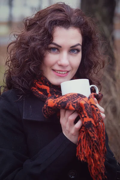 冷凍された笑顔の青い目の女性がカップから熱いお茶やコーヒーを飲みます — ストック写真