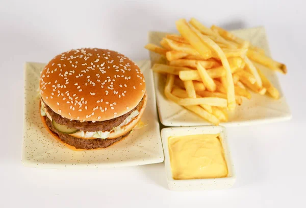 a mouth-watering Burger with sauce and potatoes on a white isolated background, concept of fast food
