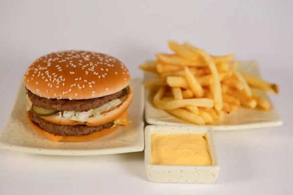 food : delicious Burger with sauce and fries in the background on a white isolated background