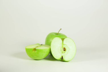 Beyaz yalıtılmış bir zemin üzerinde sulu ve olgun yeşil elmalar, sağlıklı beslenme ve vitamin kavramı