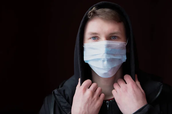 Smutny Młody Człowiek Chroni Się Przed Koronawirusem Pomocą Maski Medycznej — Zdjęcie stockowe