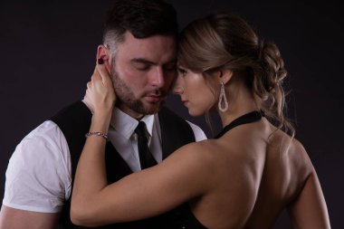 Birbirine aşık bir çiftin yakın portresi: açık renk saçlı seksi bir kız erkeğinin yanağını okşar ve onu ne kadar çok sevdiğine bakar.