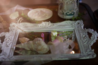 Sabah güneşleri nikah yüzüklerinin üzerine düşer. Düğün aksesuarları arasında güzelce serili.