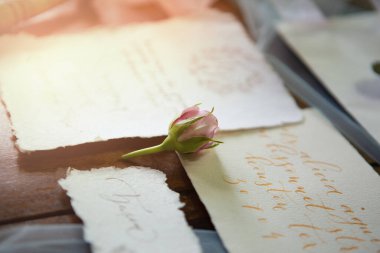 Damadın çiçeği sabah güneşinde eski moda düğün davetiyelerinde yatıyor.