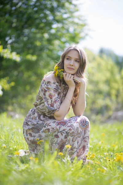 Okouzlující Dívka Dívá Stranu Zájmem Sedí Trávníku Parku Květinami Ruce — Stock fotografie