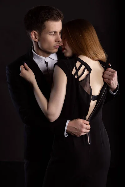 남자가 열정적 포옹을 하면서 여자의 벗기고 있습니다 어두운 배경에 유행하는 — 스톡 사진