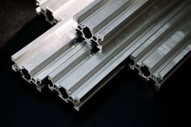 V slot alüminyum profili siyah bir masada, parlak bir fenerle çalışıyor. Bir cnc makinesinin nasıl monte edileceğini kendin yap.