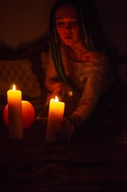 Mavi saçlı kız gece karanlik bir odada, mum yanginda ve inek kafasinda...