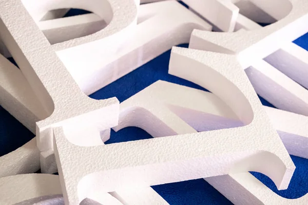 Weiße Buchstaben Aus Schaumstoff Ohne Bemalung Auf Blauem Hintergrund Rohling — Stockfoto