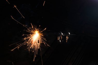 Bengal lambasında yanan altın nişan yüzüğü. Siyah arka planda turuncu kıvılcımlar. Evlilik, Noel için düğün ya da yeni yıl