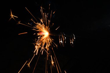 Bengal lambasında yanan altın nişan yüzüğü. Siyah arka planda turuncu kıvılcımlar. Evlilik, Noel için düğün ya da yeni yıl