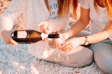 Güzel bir kız bir buket lale ile ekose üzerinde oturur. Şafakta güneşli romantik kahvaltı.