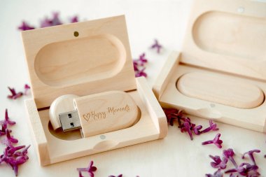Tahta kahverengi usb flaş bellek içinde kutular beyaz arka planda eflatun yapraklı Mutlu Anlar, veri depolama, müşterilere güzel geri bildirim