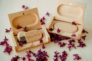 Tahta kahverengi usb flaş bellek içinde kutular beyaz arka planda eflatun yapraklı Mutlu Anlar, veri depolama, müşterilere güzel geri bildirim