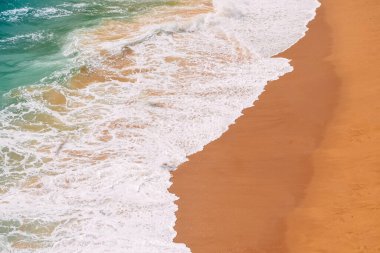 Öfkeli okyanus, kumlu kumlu gök mavisi bir sahil. Portekiz 'deki Benagil Sahili' nin en iyi manzarası.