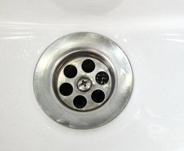 Uzun zamandır kullanılmakta olan lavaboda paslanmaz çelik ızgarayla suyu kurutuyor.