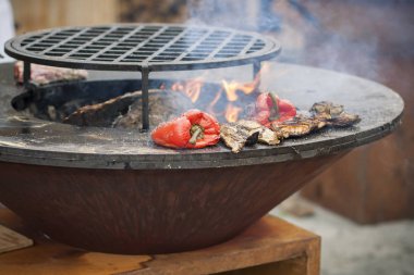 Kırmızı biber ve patates dilimleri sıcak ızgara yüzeyi bir koni şeklinde kase şeklinde pişirilir
