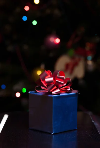 Scatola regalo colorata con candela e sfondo luci di Natale — Foto Stock