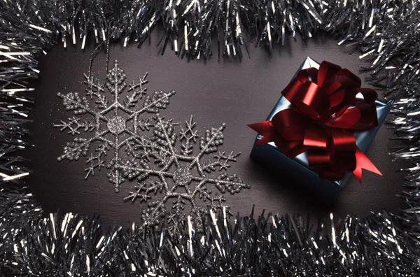 Scatola regalo con fiocchi di neve su sfondo di legno — Foto Stock