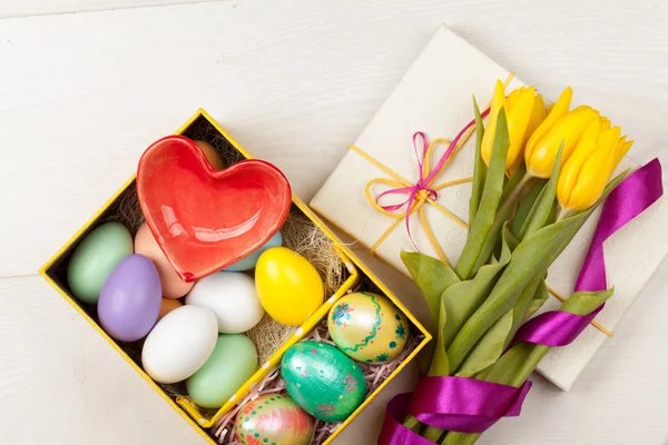 Kleurrijke Easter Eggs en tulpen ingericht in mooie geschenkdoos — Stockfoto