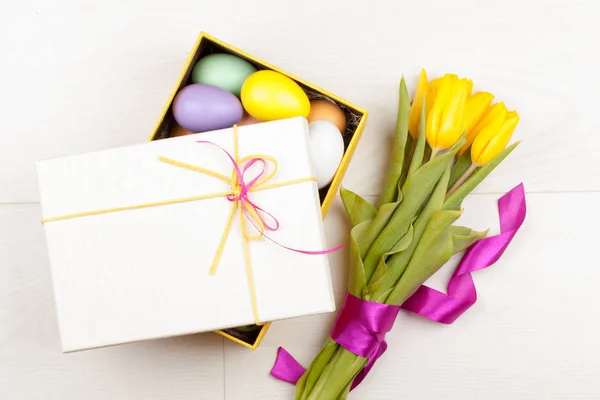 Színes a húsvéti tojás és a tulipánok díszített gyönyörű díszdobozban — Stock Fotó