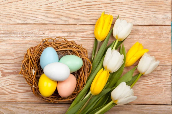 Ostereier im Vogelnest mit bunten Tulpen — Stockfoto