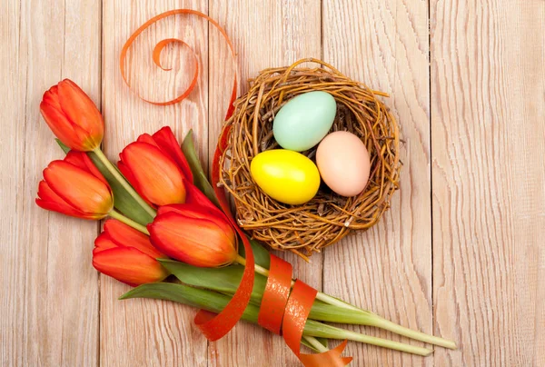 Easter Eggs in a birds nest with colorful tulips Stock Image