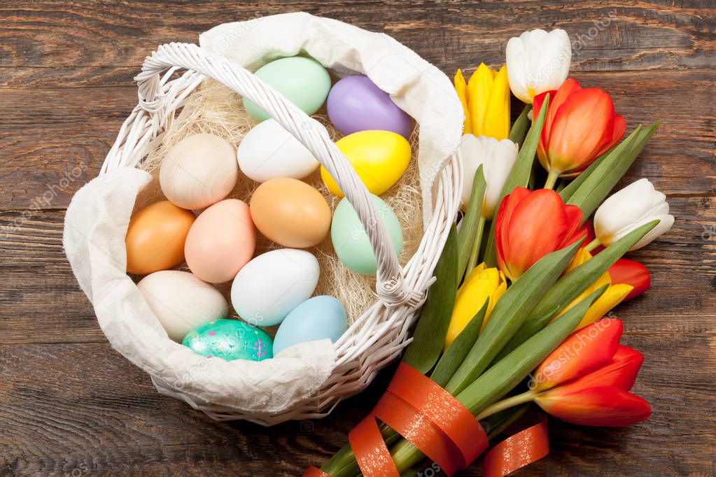 Easter Eggs in a white basket with colorful tulips