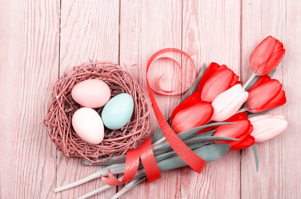 Easter Eggs in een vogelnest met kleurrijke tulpen — Stockfoto