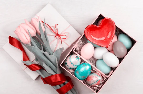 Easter Eggs in een geschenkdoos met kleurrijke gele tulpen — Stockfoto