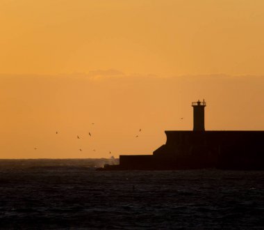 Bir gün batımı sırasında kontrast deniz feneri