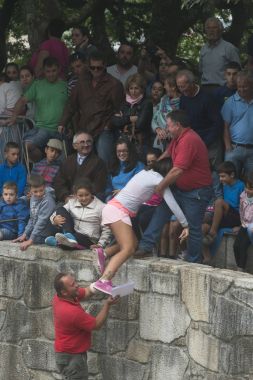 Kamu görevlisi genç bir kadın seyirci standları için tırmanmaya yardımcı olur.
