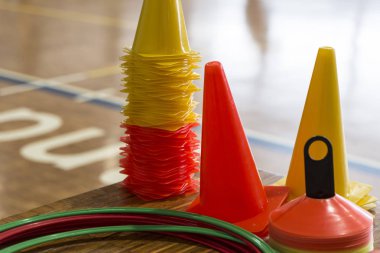 Basketbol antrenmanı için koniler ve plastik halkalar.