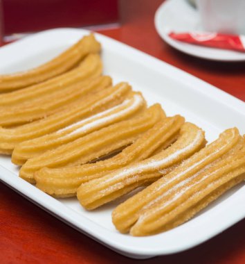 Üstünde şeker olan bir tabak churros.