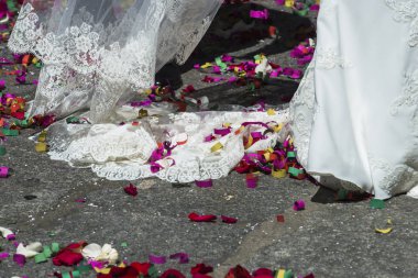 Salamanca, İspanya - 2 Eylül 2017: Gelinin gelinliğinin ayrıntıları, düğün davetlileri tarafından atılan flamalar ve renkli kağıtlarla çevrili.