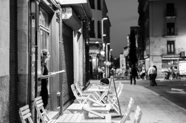 Salamanca, İspanya - 2 Eylül 2017: Bir restoranın girişinde müşterilerin gelmesini bekleyen bir kadın.