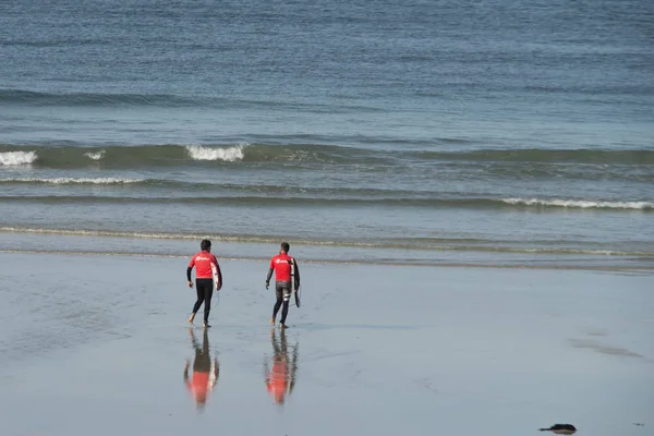 O grove, spanien - surfer spazieren mit ihrem surfboard durch die s — Stockfoto