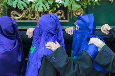 PONTEVEDRA, SPAIN - APRIL 3, 2015: A group of religious brothers, carry a heavy religious image during the celebration of Holy Week in the city.