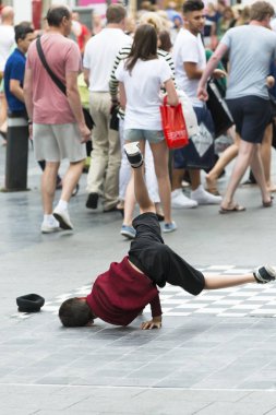 Antwerp, Belçika - 5 Temmuz 2015: Bir çocuk sokağın ortasında, yoldan geçenlerin şaşkınlığıyla fren dansı yapıyor.