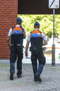 Antwerp, Belçika - 6 Temmuz 2015: İki polis memuru, şehrin sokaklarından birinde, güvenlik işlerini yapıyor.