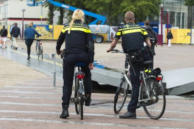 Amsterdam, Hollanda - 8 Temmuz 2015: Bisikletli bir çift polis şehrin sokaklarında devriye geziyor.