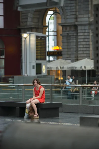 比利时安特卫普 2015年7月5日 一名身穿红色衣服的少女躺在城市中央火车站的长椅上 — 图库照片