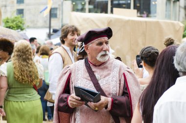 Pontevedra, İspanya - 6 Eylül 2014: Her yıl şehrin tarihi bölgesinde düzenlenen ortaçağ festivalinde elinde tablet bulunan asil elbiseli bir adam.