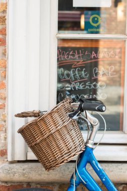 BRUGES, BELGIUM - 3 HAZİRAN 2015: Eski kasabanın sokaklarında sepeti olan bir bisikletin gidonunun ayrıntıları.