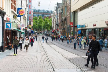 AMSTERDAM, NETHERLANDS - 8 HAZİRAN 2015: Tramvay rayları ve kaldırımları olan işlek bir yaya caddesinin detayları.