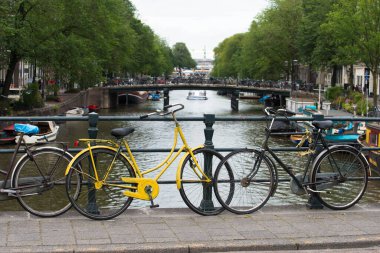 AMSTERDAM, NETHERLANDS - 8 Temmuz 2015: Köprüleri, kanalları ve park halindeki bisikletleri olan şehir manzarası, bu şehrin tipik.