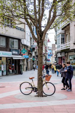 PONTEVEDRA, İspanya - 14 Nisan 2019: Köyün yaya sokaklarından birinde ağaçta park edilmiş bir bisiklet.