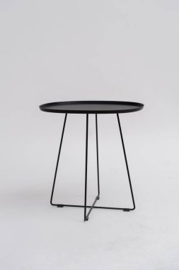 Beyaz arkaplanda siyah demir sehpa.