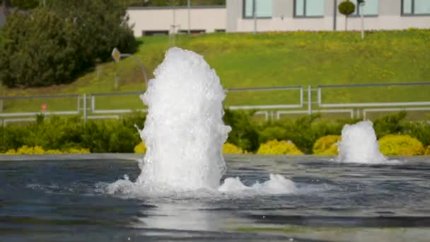 Pequeña fuente de la ciudad en un soleado día de primavera con coches pasando por el fondo — Vídeos de Stock