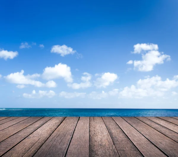 Table en bois avec paysage marin flou et fond bleu ciel — Photo